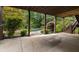 A large concrete patio under a covered deck overlooking lush landscaping and a pool at 851 Courtenay Ne Dr, Atlanta, GA 30306