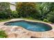 A kidney-shaped pool surrounded by stone pavers and mature landscaping at 851 Courtenay Ne Dr, Atlanta, GA 30306