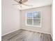 Bright bedroom features wood-look floors, white trim, a ceiling fan, and a window offering natural light at 1576 Thornwick Trce, Stockbridge, GA 30281