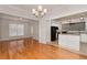 Open-concept kitchen and dining area featuring hardwood floors, a chandelier, and white cabinets at 1576 Thornwick Trce, Stockbridge, GA 30281