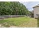 Spacious backyard featuring a well-maintained lawn, wooden fence, and covered patio; perfect for outdoor activities and relaxation at 446 Vandenburg Dr, Villa Rica, GA 30180