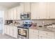 A kitchen featuring stainless steel appliances, granite countertops, and ample white cabinetry at 446 Vandenburg Dr, Villa Rica, GA 30180