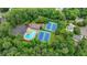 Aerial view of neighborhood pool and tennis courts surrounded by lush greenery and homes at 5507 Martina Way, Dunwoody, GA 30338