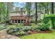 A backyard with stone pathway, manicured lawn, tiered deck, and lush landscaping at 5507 Martina Way, Dunwoody, GA 30338