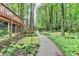 Beautiful backyard landscaping featuring a stone walkway to the house and mature trees behind the property at 5507 Martina Way, Dunwoody, GA 30338