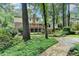 Backyard view showcasing a multi-level deck, a manicured lawn, and mature trees at 5507 Martina Way, Dunwoody, GA 30338
