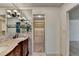 Bathroom featuring a double sink vanity with marble countertop, a large mirror and adjacent walk-in closet at 5507 Martina Way, Dunwoody, GA 30338