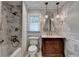 This bathroom is updated with a marble tile shower and flooring and a dark wood vanity at 5507 Martina Way, Dunwoody, GA 30338