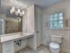 Bright bathroom with a large mirror, neutral-toned walls, modern fixtures, toilet and natural light at 5507 Martina Way, Dunwoody, GA 30338
