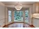 Dining area with bay windows overlooking lush landscaping and chandelier at 5507 Martina Way, Dunwoody, GA 30338