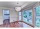 Bright dining area with bay windows overlooking lush landscaping and modern chandelier at 5507 Martina Way, Dunwoody, GA 30338