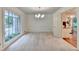 Bright dining room with a modern chandelier and views into kitchen with stainless appliances at 5507 Martina Way, Dunwoody, GA 30338