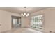 Bright dining room with a modern chandelier and large picture window overlooking the front yard at 5507 Martina Way, Dunwoody, GA 30338