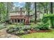 Exterior shot with a deck that overlooks a beautifully landscaped yard with mature trees and stone path at 5507 Martina Way, Dunwoody, GA 30338