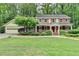 Charming two-story home featuring a welcoming front porch, red shutters, and a beautifully landscaped front yard at 5507 Martina Way, Dunwoody, GA 30338