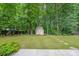 Well-maintained backyard features a shed and lush green grass, backing up to a wooded area at 780 Karingway Nw Ln, Kennesaw, GA 30152