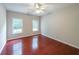 A bedroom featuring hardwood floors, ceiling fan, and natural light streaming through the windows at 780 Karingway Nw Ln, Kennesaw, GA 30152