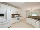 Well-lit kitchen with white cabinets, stainless steel appliances, and tile floors at 780 Karingway Nw Ln, Kennesaw, GA 30152