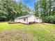 Expansive backyard featuring a wooden deck, lush green grass, and mature trees at 2734 Amber Springs Way, Buford, GA 30519