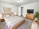 Staged bedroom featuring a bed, dresser with TV, and neutral decor at 2734 Amber Springs Way, Buford, GA 30519