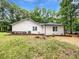 View of the home featuring white siding and a well-maintained yard with mature trees at 2734 Amber Springs Way, Buford, GA 30519