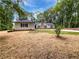 Beautiful home with striking windows and a stone chimney surrounded by lush trees and a freshly laid lawn at 2734 Amber Springs Way, Buford, GA 30519