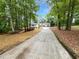 Charming home with a long driveway surrounded by lush green trees at 2734 Amber Springs Way, Buford, GA 30519