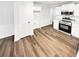 Kitchen featuring stainless steel appliances, white cabinetry, and LVP flooring at 2734 Amber Springs Way, Buford, GA 30519