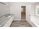 Bathroom featuring dual sinks, granite countertop, grey floor tile, soaking tub, and window at 365 Hunt Creek Dr, Acworth, GA 30101
