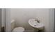 Powder room with a white toilet and pedestal sink features modern fixtures and neutral wall color at 365 Hunt Creek Dr, Acworth, GA 30101