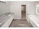 Bathroom featuring dual sinks, granite countertop, grey floor tile, soaking tub, and window at 365 Hunt Creek Dr, Acworth, GA 30101