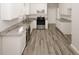 Bright kitchen with granite countertops, white cabinets and wood-look tile flooring at 365 Hunt Creek Dr, Acworth, GA 30101
