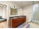Modern bathroom with double sinks, granite countertops, a large mirror, and a glass-enclosed shower at 44 Peachtree Ne Pl # 1824, Atlanta, GA 30309