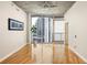 Bright living room featuring hardwood floors, large windows, and sliding glass door to balcony with city views at 44 Peachtree Ne Pl # 1824, Atlanta, GA 30309