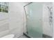 Bright bathroom featuring a modern glass shower, marble style tile and a sunny window at 612 Champions Dr, Mcdonough, GA 30253