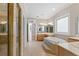 Bathroom featuring a large tiled tub, vanity, and natural light at 612 Champions Dr, Mcdonough, GA 30253