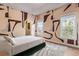 Bedroom with modern bed, hardwood flooring, and natural light at 612 Champions Dr, Mcdonough, GA 30253