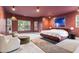 An interior view of a modern bedroom with marsala-painted walls, white seating, and tree views at 612 Champions Dr, Mcdonough, GA 30253
