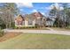 Charming two-story brick home featuring a well-manicured lawn and mature landscaping at 612 Champions Dr, Mcdonough, GA 30253