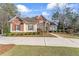 Charming two-story brick home featuring a well-manicured lawn and mature landscaping at 612 Champions Dr, Mcdonough, GA 30253
