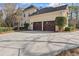 Attached two-car garage with an expansive driveway and manicured shrubbery at 612 Champions Dr, Mcdonough, GA 30253