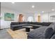 Spacious living room featuring a modern sectional sofa with a black coffee table, and neutral toned decor at 612 Champions Dr, Mcdonough, GA 30253