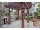 This outdoor kitchen features a grill, sink, and stainless steel storage beneath a wood pergola at 612 Champions Dr, Mcdonough, GA 30253