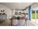 Open concept kitchen featuring stainless appliances, a large island, and a dining area with backyard access at 1208 Arnhem Dr, Hampton, GA 30228