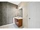 Bathroom with grey wall paneling, white tile flooring, wood vanity with sink, and lighted mirror at 1212 Ashton Park Dr, Lawrenceville, GA 30045