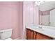 Small bathroom featuring pink walls, stained vanity with sink, and a walk-in shower at 1212 Ashton Park Dr, Lawrenceville, GA 30045