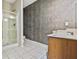 Bathroom with walk-in shower, wood vanity, sink and modern wall paneling at 1212 Ashton Park Dr, Lawrenceville, GA 30045