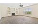 Carpeted living room featuring a fireplace, built-in shelves, and a bright, airy window at 1212 Ashton Park Dr, Lawrenceville, GA 30045