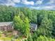 Aerial view of a brick home with manicured lawn surrounded by a dense green forest, perfect for nature lovers at 1625 Clark Lake Nw Dr, Acworth, GA 30102
