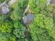 Aerial view of the home nestled among mature trees with a driveway leading to the property at 1625 Clark Lake Nw Dr, Acworth, GA 30102